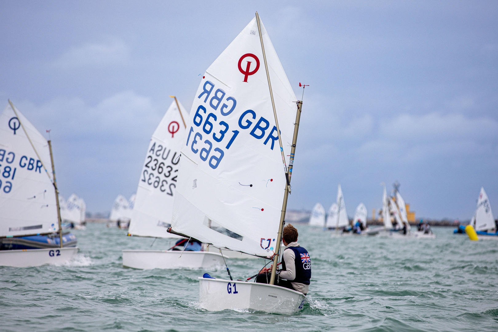 Optimist in team racing sotto la pioggia al Trofeo Marco Rizzotti con vele bagnate e equipaggi concentrati