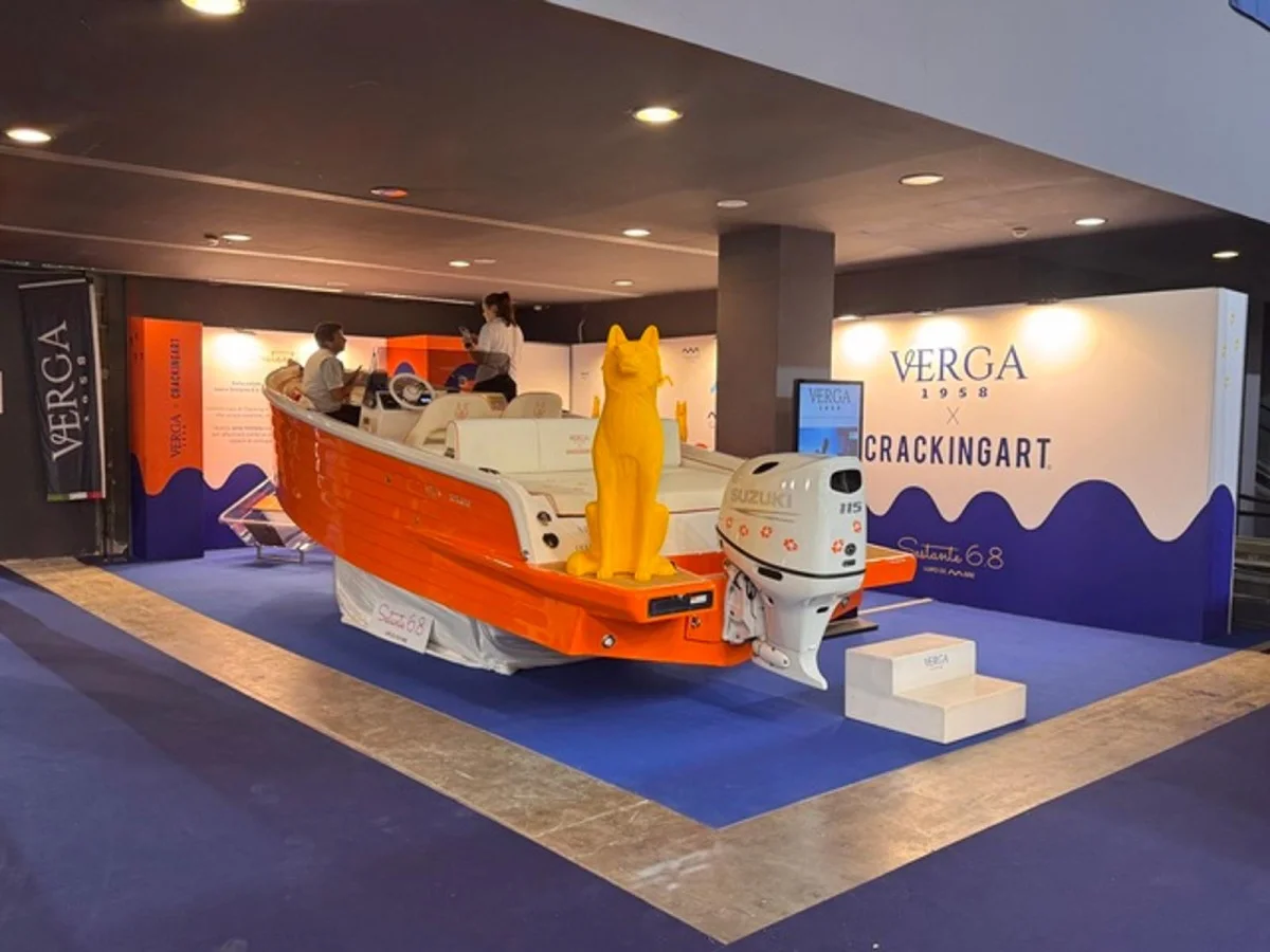 Stand fieristico con la barca arancione esposta, contesto dell'evento e allestimento visibile.