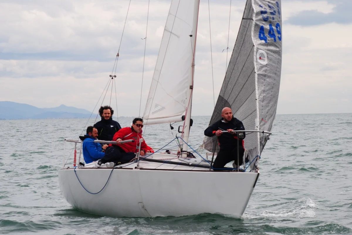 Equipaggio J/24 numero 449 in regata in bolina sul mare increspato, con cielo nuvoloso.