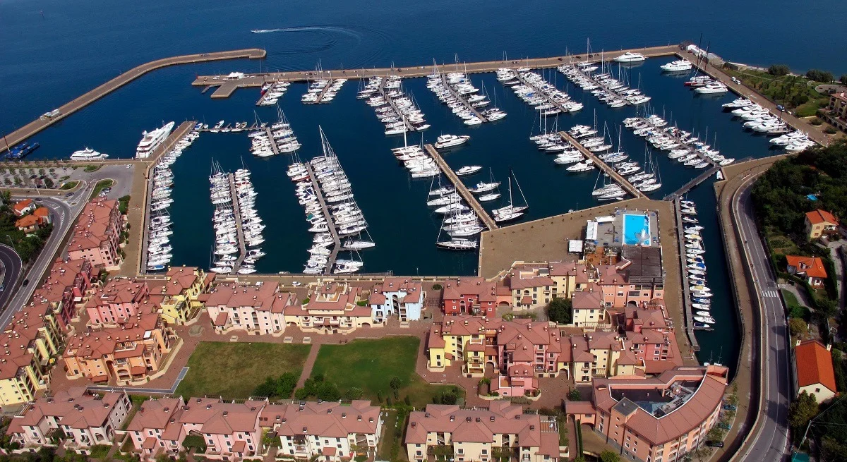 Inquadratura aerea ravvicinata del marina con pontili, barche ormeggiate e caratteristici edifici colorati sul lungomare