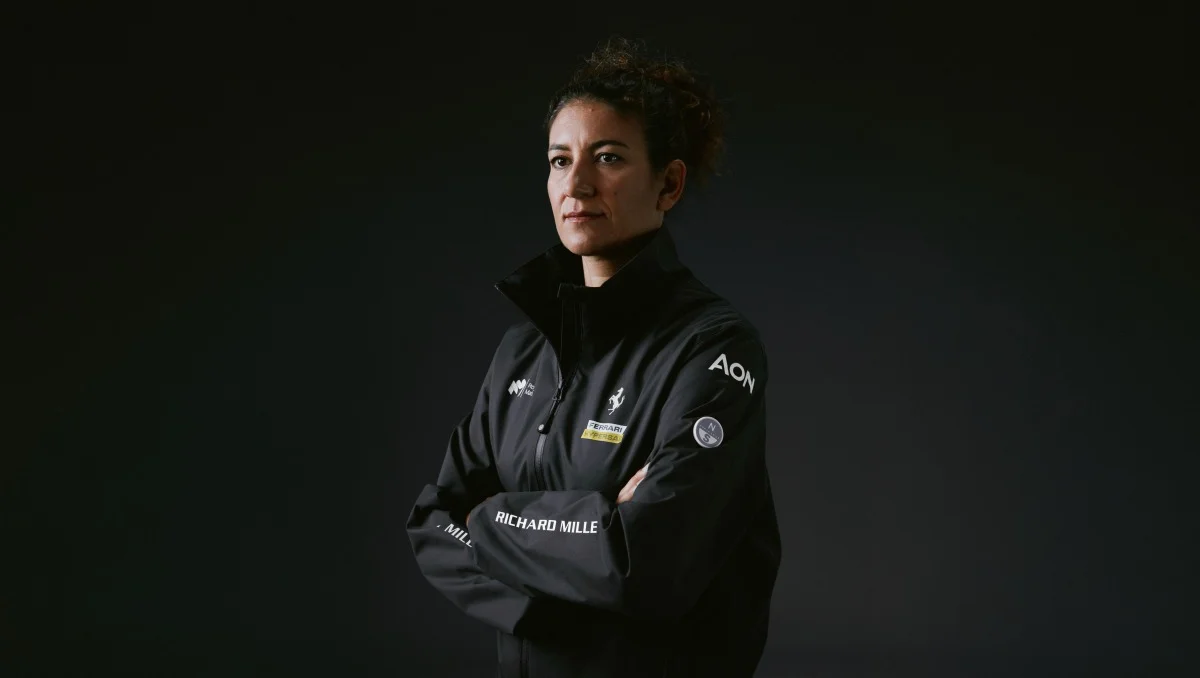 Ritratto a mezzo busto di una donna con giacca tecnica Ferrari Hypersail su sfondo scuro, adatto come immagine nel corpo articolo.