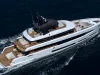 Superyacht bianco di 42 metri in navigazione visto dall'alto, con ampie aree esterne in teak