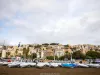 Derive coperte sui carrelli sulla spiaggia, con cielo nuvoloso e case colorate sulla collina sullo sfondo
