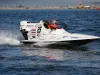 Monoscafo da gara GT30 bianco con pilota dal casco arancione che sfreccia sull'acqua