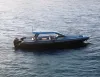 Gommone scuro con hard top azzurro e due motori fuoribordo in navigazione su mare calmo, visto dall'alto