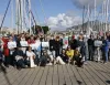 Gruppo di partecipanti su un pontile davanti a barche a vela nel porto di Palermo