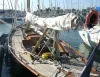 Barca a vela tradizionale ormeggiata in porto con randa ammainata e cime sul ponte