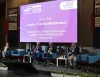 Quattro relatori seduti su poltrone blu sul palco di un convegno, davanti a un grande schermo con il titolo "Il Lazio – Hub EuroMediterraneo"