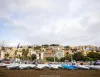 Derive coperte sui carrelli sulla spiaggia, con cielo nuvoloso e case colorate sulla collina sullo sfondo