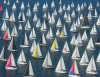 Grande numero di barche a vela con vele bianche e alcuni spinnaker colorati su un mare calmo