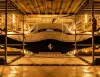 Prua di Ferrari Hypersail in cantiere, tra ponteggi, con scafo scuro, logo del Cavallino rampante e scritta Ferrari Hypersail