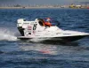 Monoscafo da gara GT30 bianco con pilota dal casco arancione che sfreccia sull'acqua
