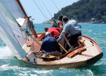 Imbarcazione a vela d'epoca in navigazione con equipaggio su mare azzurro