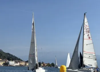 Due imbarcazioni a vela vicino a una boa gialla nel Golfo di Salò durante la regata.