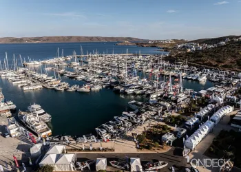 Marina con numerose imbarcazioni ormeggiate e padiglioni espositivi lungo la banchina