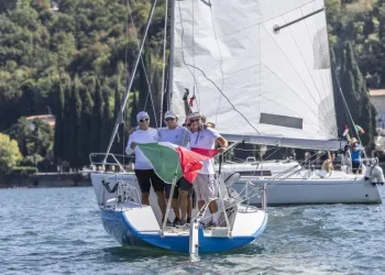 Equipaggio su Protagonist 7.50 con bandiera italiana a prua durante i festeggiamenti a Salò