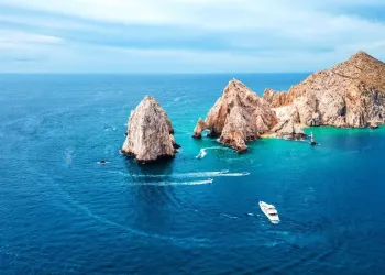 Yacht naviga vicino a formazioni rocciose sulla costa pacifica messicana in acque turchesi
