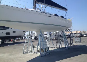 Scafo di una barca a vela sollevato su cavalletti in un cantiere navale