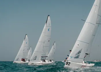 Serie di J/70 in regata sul Golfo Persico con vele bianche e numeri velici visibili
