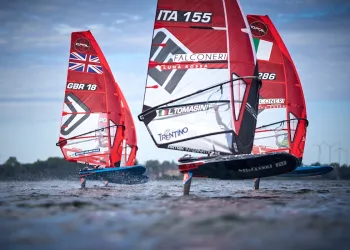 Surf foil in regata con vele rosse, tra cui ITA 155 con il nome L. Tomasini visibile