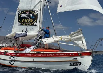 Imbarcazione da regata con vele ridotte e equipaggio al lavoro durante mare formato