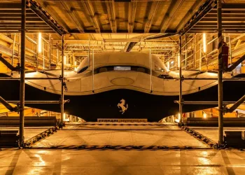 Prua di Ferrari Hypersail in cantiere, tra ponteggi, con scafo scuro, logo del Cavallino rampante e scritta Ferrari Hypersail