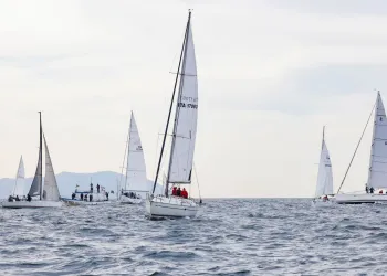 Più barche a vela in navigazione sul mare con onde leggere e cielo nuvoloso
