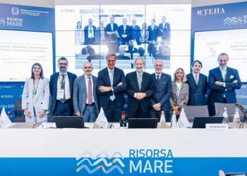 Gruppo di relatori in piedi dietro un tavolo con il logo Risorsa Mare durante un convegno