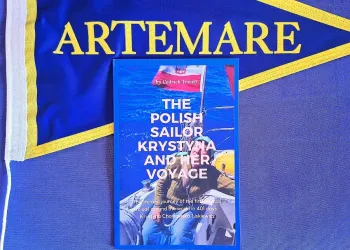 Copertina del libro 'The Polish Sailor Krystyna and Her Voyage' appoggiata su una bandiera con la scritta ARTEMARE