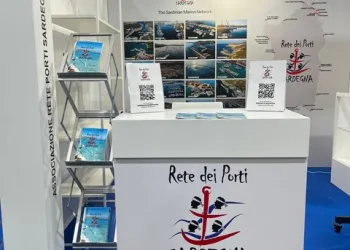 Stand fieristico della Rete dei Porti Sardegna con desk, brochure e pannelli fotografici promozionali