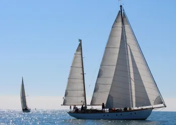 Due vele classiche a pieno vento su mare calmo durante una regata costiera