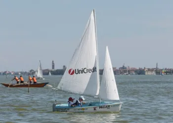 Due velisti su una Hansa 303 con vela sponsorizzata UniCredit nella laguna di Venezia