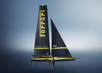 Catamarano da regata con vela nera recante la scritta Ferrari e dettagli gialli