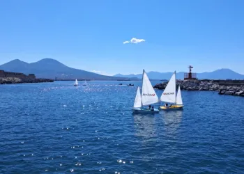 Due derive con vele bianche sul mare di Bagnoli, il Vesuvio sullo sfondo