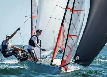 Due velisti su una deriva con spinnaker in regata sul mare