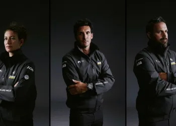 Tre membri del Sailing Team Ferrari Hypersail in giacche ufficiali, ritratti in primo piano su sfondo scuro