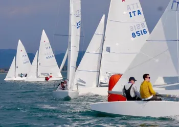 Barche della Classe Star in regata sul mare, vele bianche e boa arancione in acqua