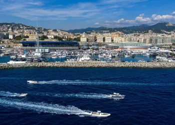 Porto e banchine affollate di imbarcazioni con il profilo urbano sullo sfondo
