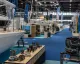 Stand con barche, motori e accessori esposti in un ampio padiglione fieristico con moquette blu