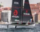Monoscafo foiling Alinghi con vele sponsorizzate davanti al lungomare di Napoli