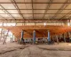 Scafo in legno di uno yacht sostenuto su cavalletti all'interno di un capannone di cantiere
