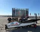 Barca WASZP sulla spiaggia con un gruppo di persone e un palco del Race Village sullo sfondo