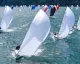 Flotta di J/70 con spinnaker bianchi in regata nelle acque di Porto Cervo