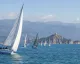 Vele e imbarcazioni da regata in acqua con l'Isola Palmaria e la costa sullo sfondo.